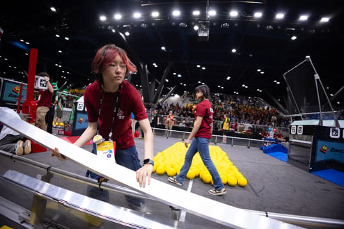 A volunteer works on field at FIRST Championship to move different structures.