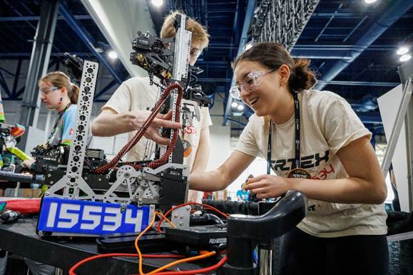 Two students on team 15534 can be seen working on their robot.