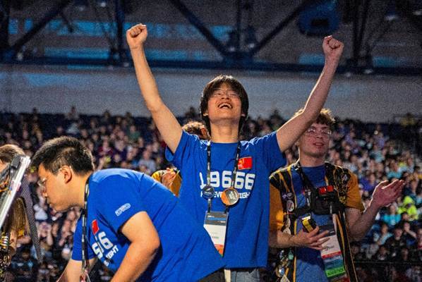 An FTC student raises his arms in victory, smiling excitedly.