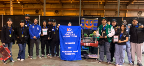 The Steel Stingers pose with the Hueneme Port Regional winner award 2024. They are smiling and posing with their robot.