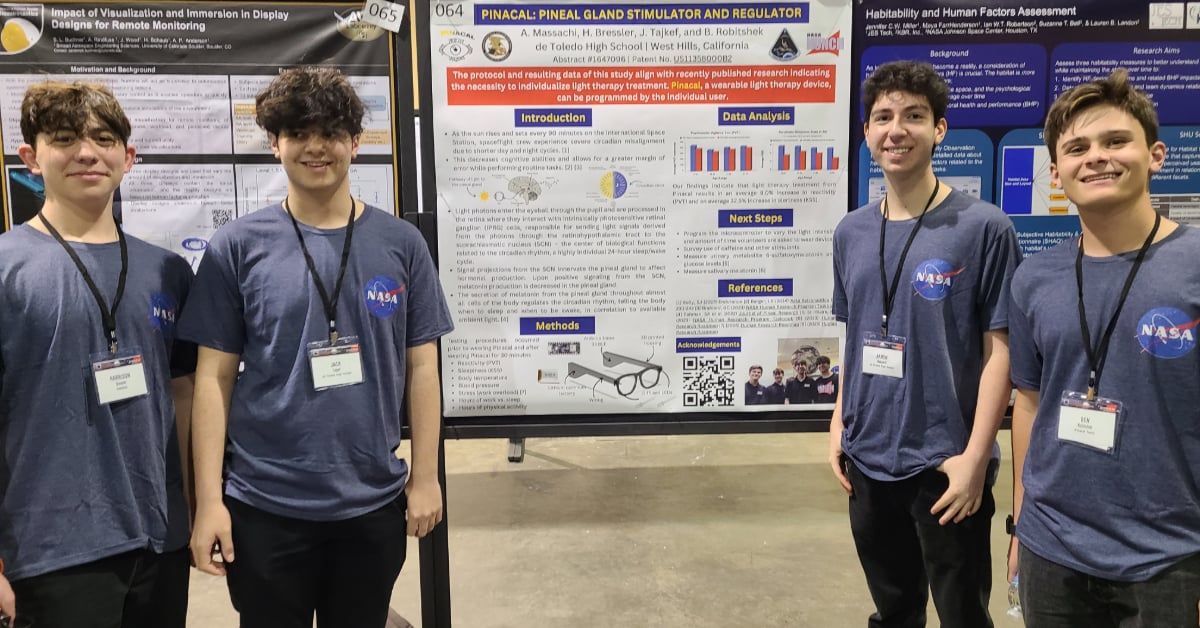 Team Heschel RoboHawks smile in front of their project poster at the NASA presentation.
