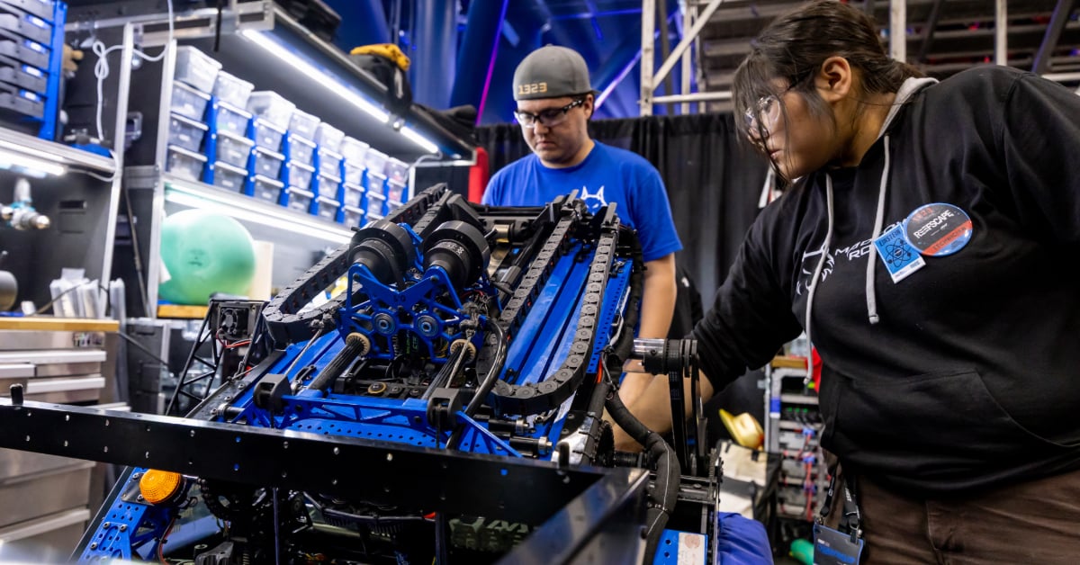 A student and their mentor working on their robot at Championship.