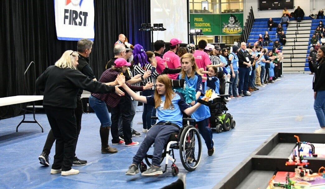 Youth participants receive high fives at a FIRST event.