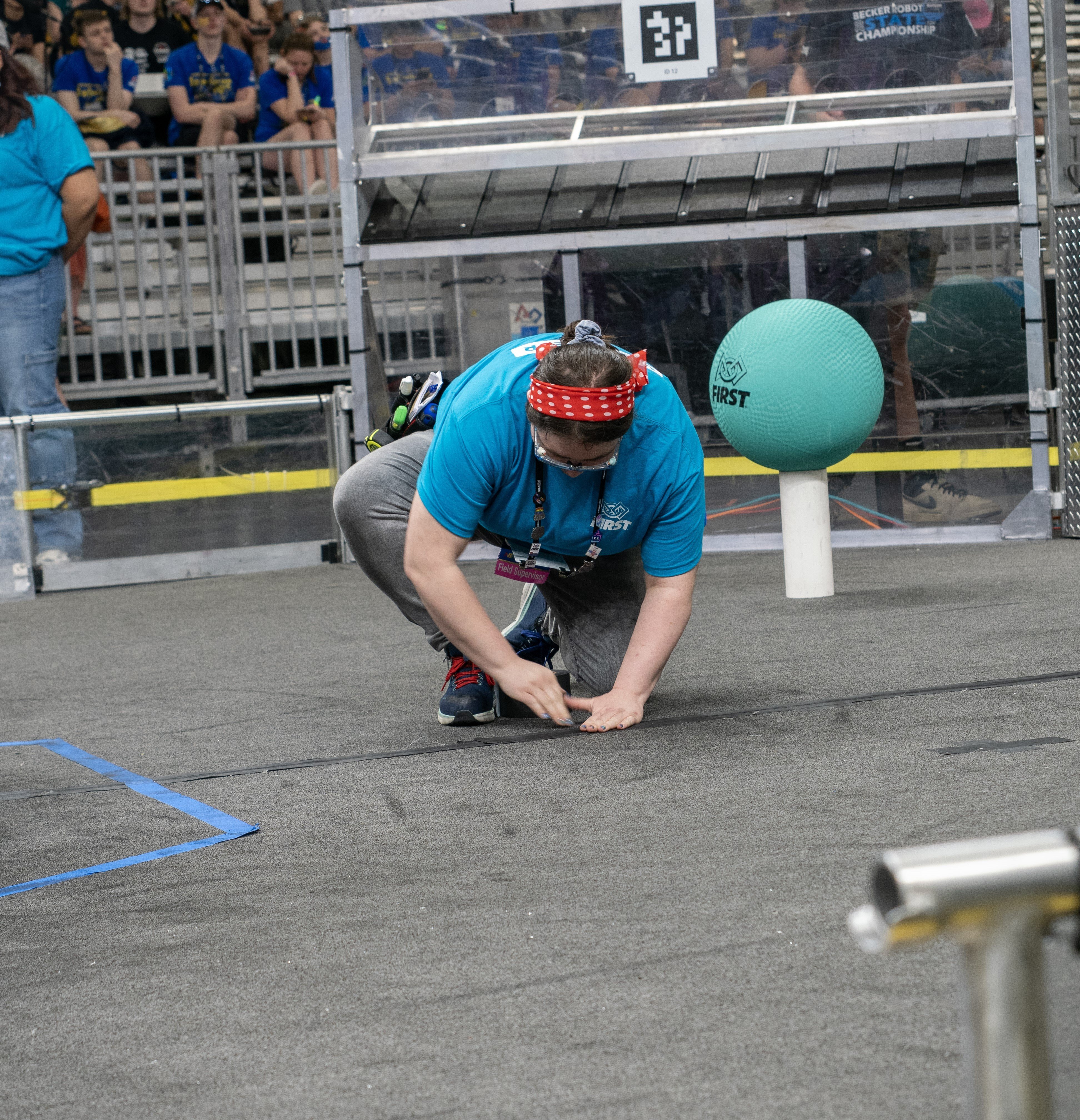 A volunteer taping the carpet