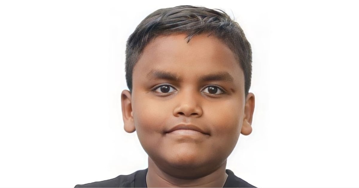 Sumit smiles and poses in front of a white background